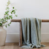 Beautiful home decor with Sage blanket, wooden bench, and plant - BAMBONI® TODDLER BLANKETS - Saranoni