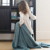 Young girl dragging her favorite Spruce BAMBONI TODDLER BLANKETS - Saranoni