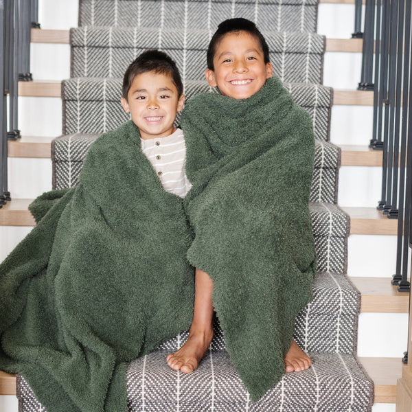 Two young boys smiling on staircase, wrapped together in Juniper  BAMBONI TODDLER BLANKETS - Saranoni