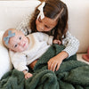 Baby girl and older sister snuggling in soft and comfy Juniper colored BAMBONI® TODDLER BLANKETS - Saranoni