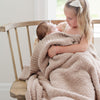 Sister rocking baby girl to sleep in Birch BAMBONI TODDLER BLANKETS - Saranoni