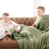 Two brothers sitting on couch wrapped in Olive Green BAMBONI TODDLER BLANKETS - Saranoni