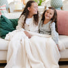 Two girls laughing and playing with beautiful Ivory BAMBONI® TODDLER BLANKETS - Saranoni