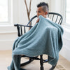 Little boy rocking in chair with Spruce BAMBONI TODDLER BLANKETS - Saranoni