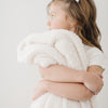 Young girl hugging her beautiful, super soft Ivory BAMBONI TODDLER BLANKETS - Saranoni