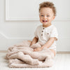 Smiling young boy playing on floor with Birch BAMBONI TODDLER BLANKETS - Saranoni