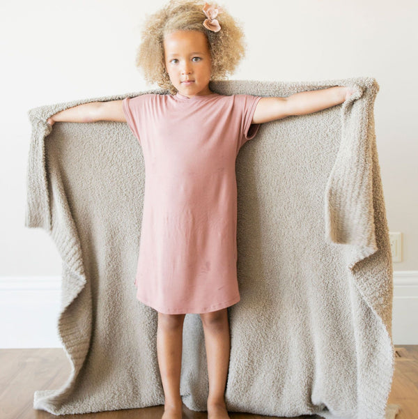 Young girl in pink dress and bow wrapping herself in Taupe BAMBONI TODDLER BLANKETS - Saranoni