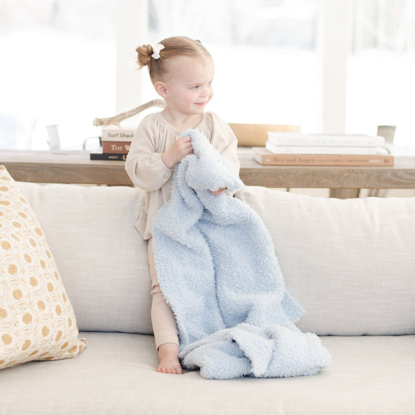 Sweet young girl playing on the couch with her soft and stretchy Light Blue BAMBONI TODDLER BLANKETS - Saranoni