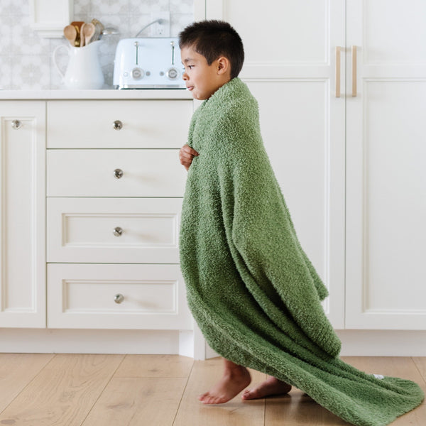 Young boy running around with super soft Olive BAMBONI TODDLER BLANKETS - Saranoni