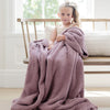 Little girl sitting on wooden bench with her favorite blanket - WoodroseBAMBONI TODDLER BLANKETS - Saranoni