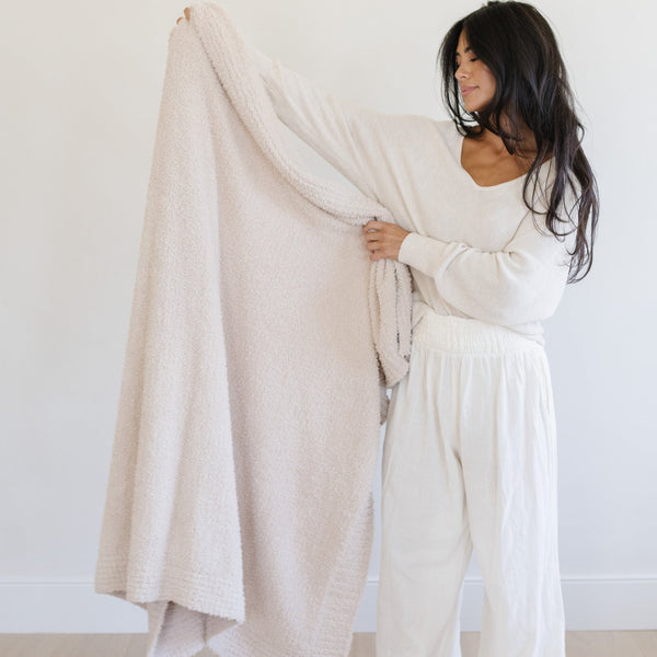 Woman holding up beautiful, extra large Buttermilk BAMBONI® XL BLANKETS - Saranoni