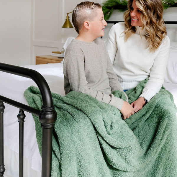 Mom and son sitting with each other, cuddling with Olive green BAMBONI XL BLANKETS - Saranoni