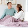 Husband and wife snuggling together in bed with super soft Woodrose BAMBONI XL BLANKETS - Saranoni