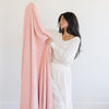 Woman snuggling up to beautiful and cozy Peach BAMBONI® XL BLANKETS - Saranoni