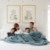 Family snuggling together in bed with beautiful Spruce BAMBONI XL BLANKETS - Saranoni