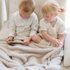 Two siblings playing with super comfy Buttermilk BAMBONI® XL BLANKETS - Saranoni