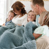 Family of five snuggling together in Spruce BAMBONI XL BLANKETS - Saranoni