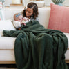 Little girl holding baby sister on couch, both wrapped in Juniper BAMBONI® XL BLANKETS - Saranoni