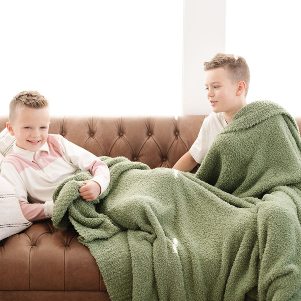 Two brothers playing on couch with stretchy soft Olive Green BAMBONI XL BLANKETS - Saranoni