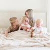 Beautiful family snuggled in bed with super cozy Ivory BAMBONI® XL BLANKETS - Saranoni