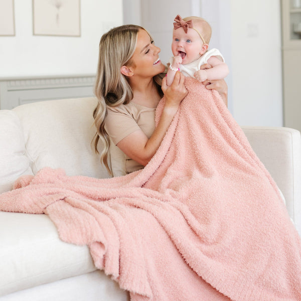 A mother, her little girl, and a Bamboni® blanket by Saranoni. This ultra-soft blanket is a peach blanket and made from a premium blend of bamboo rayon and poly microfiber, offering a lightweight, breathable, and fluffy feel. Perfect as a extra large blanket, luxury blanket, or soft blanket, it adds warmth and elegance to any living room, bedroom, or home décor setting. Designed for ultimate comfort, this buttery-soft Saranoni blanket is ideal for gifting. Enjoy this cozy blanket for years to come! 