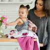 Mother and daughter together with a beautiful pink and purple colored floral bamboo muslin quilt. 