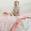 Soft and cozy pink and white floral bamboo rayon muslin quilt with a playful pattern, perfect for keeping your little one warm and comfortable.