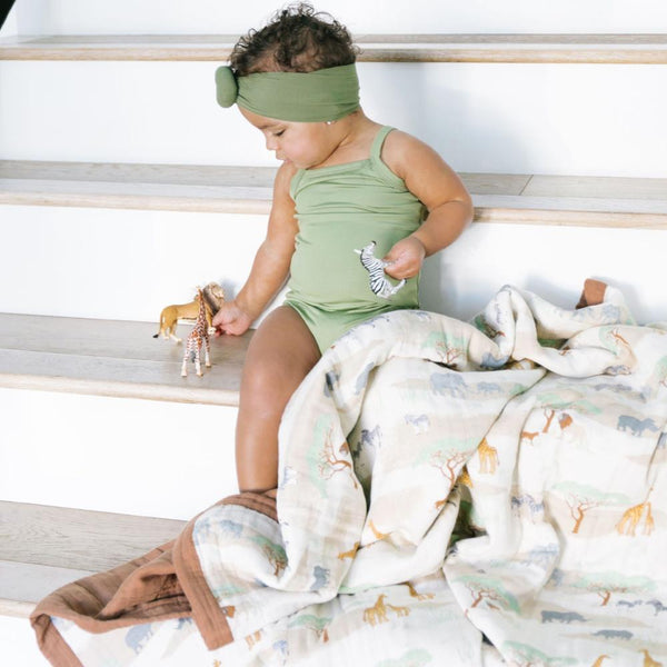 Little girl playing and enjoying an elegant bamboo rayon muslin quilt with a striking pattern, offering a blend of comfort, breathability, and style.