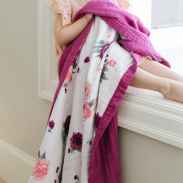 A colorful pink and purple floral bamboo muslin quilt. 