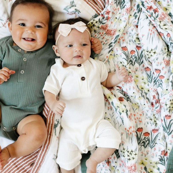 Two babies laying on beautifully patterned bamboo rayon muslin quilts. 