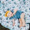 Baby girl laying on a cozy and soft bamboo rayon muslin quilt with a delightful pattern, perfect for wrapping your child in comfort.