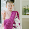 Little girl with a whimsical bamboo rayon muslin quilt for kids, featuring a lively floral pattern that adds a playful touch.