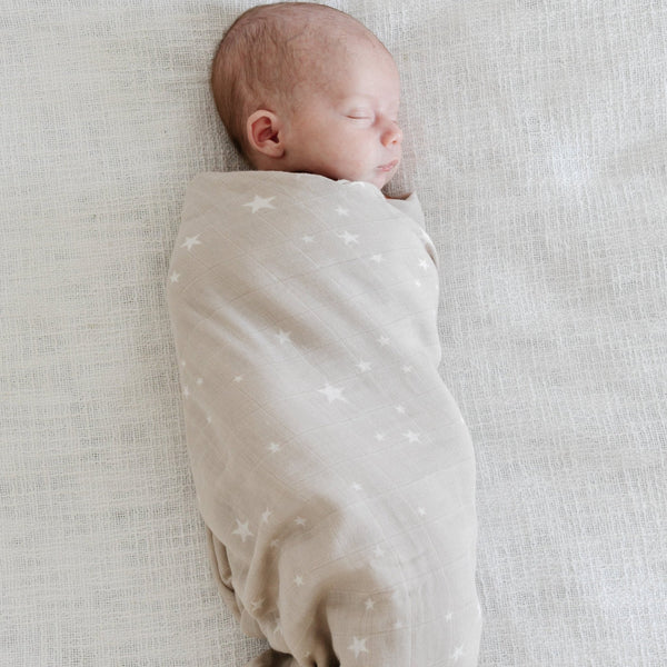 Newborn baby wrapped in a lightweight bamboo muslin swaddle, designed to keep your baby cozy and cool with a soft, airy feel.