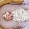 Newborn girl wrapped in an ultra-cozy and soft baby swaddle, offering a luxurious embrace for your newborn.