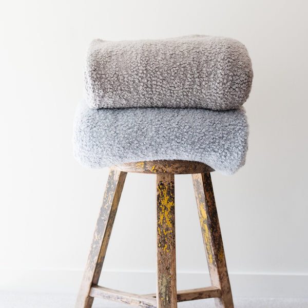 Stack of two gray and light blue comfy boucle blankets - Saranoni