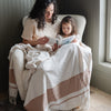 Mother and daughter sharing a cozy moment with a book and a chenille fringe blanket - Saranoni