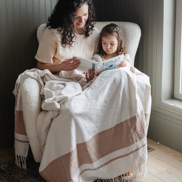 Family reading time: parent and child nestled beneath a soft cream xl throw, engrossed in a storybook - Saranoni