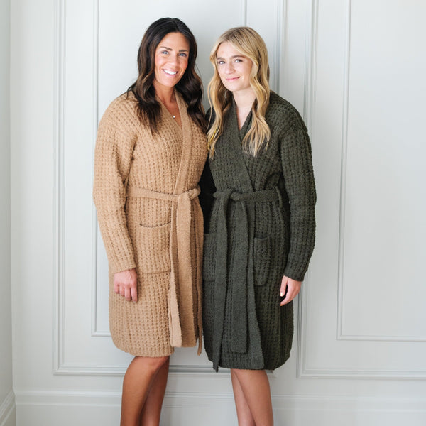 Mom and daughter standing next to each other wearing tan and olive waffle knit robes.