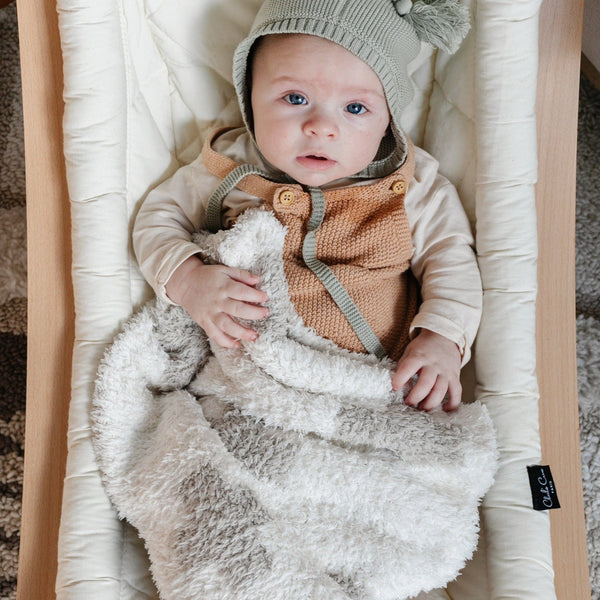 Baby boy in bassinet, wrapped in adorable and extra stretchy Swiss Cross DOUBLE-LAYER BAMBONI MINI BLANKETS - Saranoni