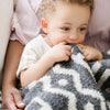 Baby boy snuggling into soft and stretchy Mudcloth DOUBLE-LAYER BAMBONI MINI BLANKETS - Saranoni