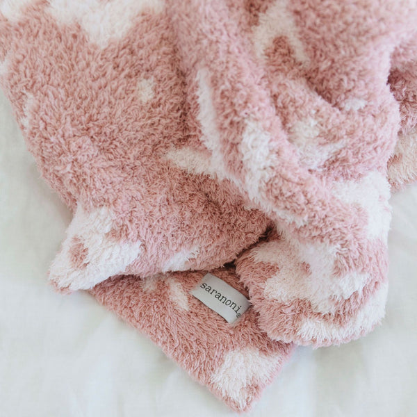 A double-layer Bamboni® baby blanket. The plush, breathable blanket features a two-tone light pink and pink floral design, offering ultimate softness and warmth. Made from Saranoni’s signature stretchy, cloud-like Bamboni® fabric, this luxury baby blanket provides comfort for naps, tummy time, and on-the-go snuggles. The soft blanket is a mini blanket and Saranoni blanket. 