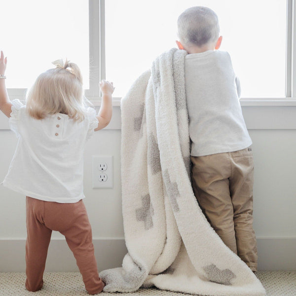 Little siblings playing with super soft, thick, cozy Swiss Cross DOUBLE-LAYER BAMBONI RECEIVING BLANKETS - Saranoni