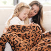 Mom and little girl snuggling on couch with soft, cozy, and thick Classic Leopard DOUBLE-LAYER BAMBONI RECEIVING BLANKETS - Saranoni