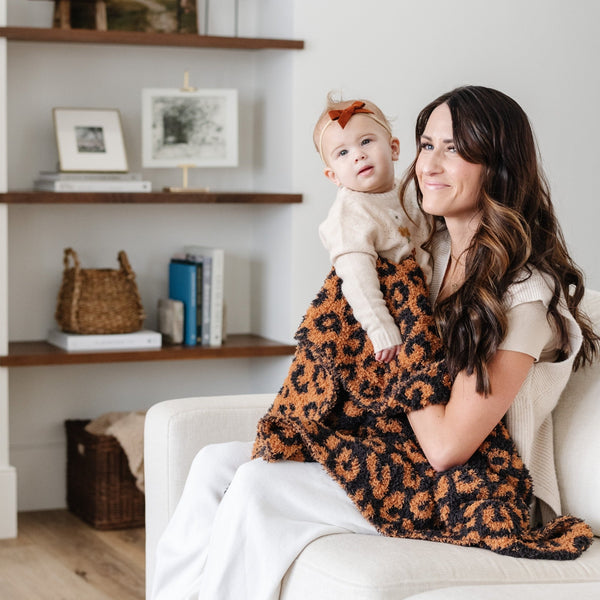 Mom and little girl sitting together with extra soft and thick Classic Leopard DOUBLE-LAYER BAMBONI® RECEIVING BLANKETS - Saranoni