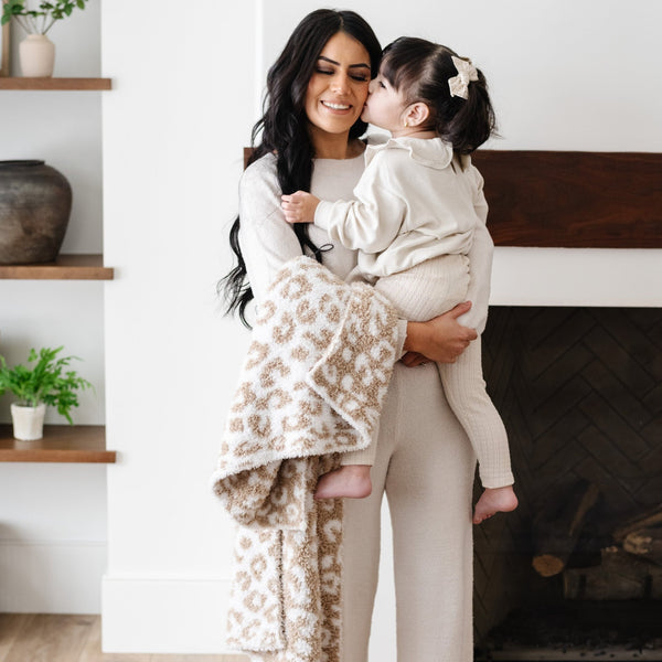 Little girl giving mom a kiss, holding on to beautiful, cozy, soft, Tan Leopard DOUBLE-LAYER BAMBONI® RECEIVING BLANKETS - Saranoni