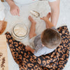 Family making cookies in the kitchen with little boy sitting on Classic Leopard DOUBLE-LAYER BAMBONI RECEIVING BLANKETS - Saranoni