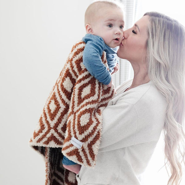 Mom giving baby boy kisses, wrapped in cozy Khmer DOUBLE-LAYER BAMBONI RECEIVING BLANKETS - Saranoni