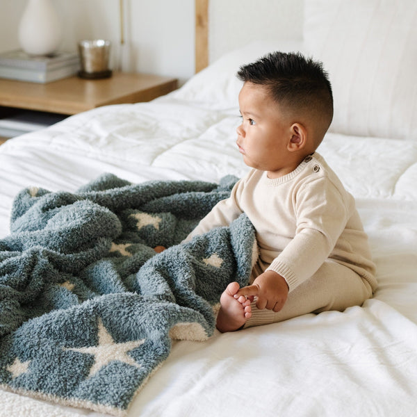 Little boy playing on bed with Nightfall (Blue/Stars) DOUBLE-LAYER BAMBONI® RECEIVING BLANKETS - Saranoni