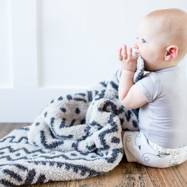 Baby boy sitting on floor, playing with super soft and stretchy Mudcloth DOUBLE-LAYER BAMBONI RECEIVING BLANKETS - Saranoni