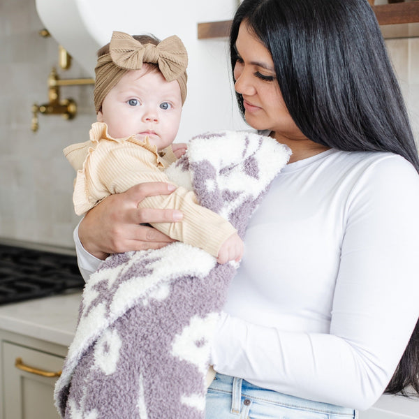 Mom and little girl in the kitchen, wrapped in adorable and stretchy Purple Floral DOUBLE-LAYER BAMBONI RECEIVING BLANKETS - Saranoni